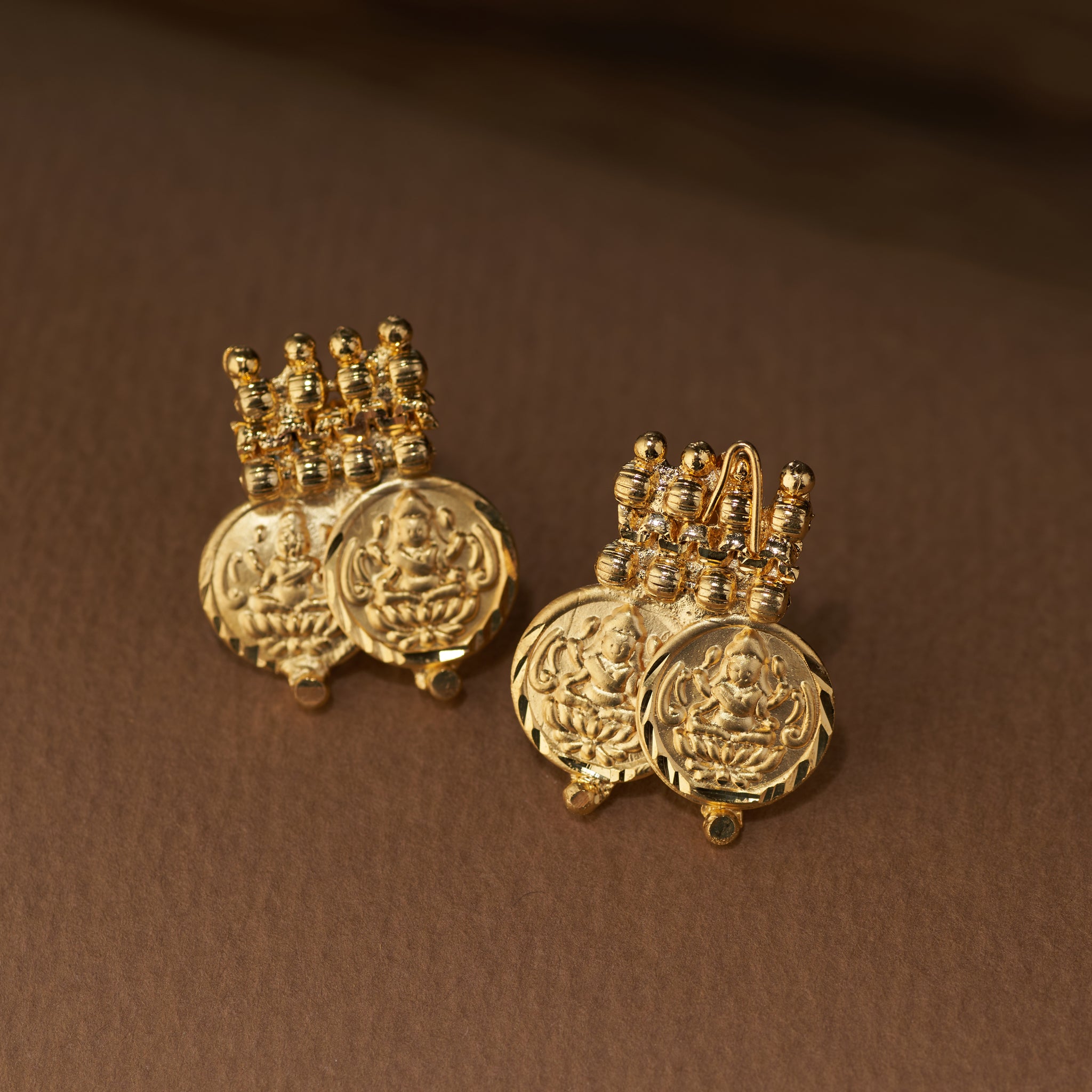 A traditional gold coin necklace set featuring a double row of detailed Lakshmi coins and a beaded chain, displayed with matching stud earrings.