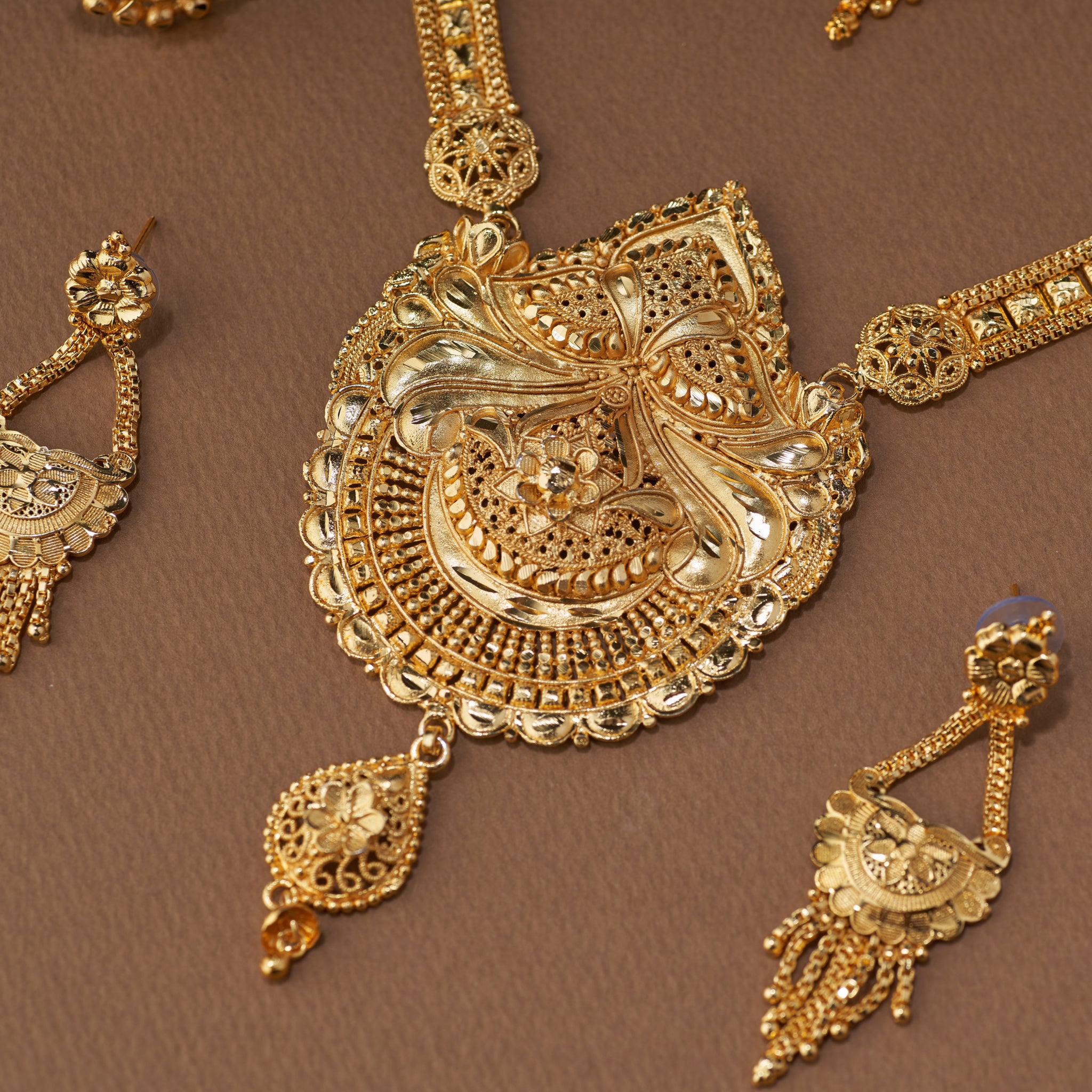 Traditional gold forming bridal jewellery set with short necklace, choker, long haaram, earrings, maang tikka and ring – perfect Indian bridal wedding jewellery with intricate temple-inspired design.