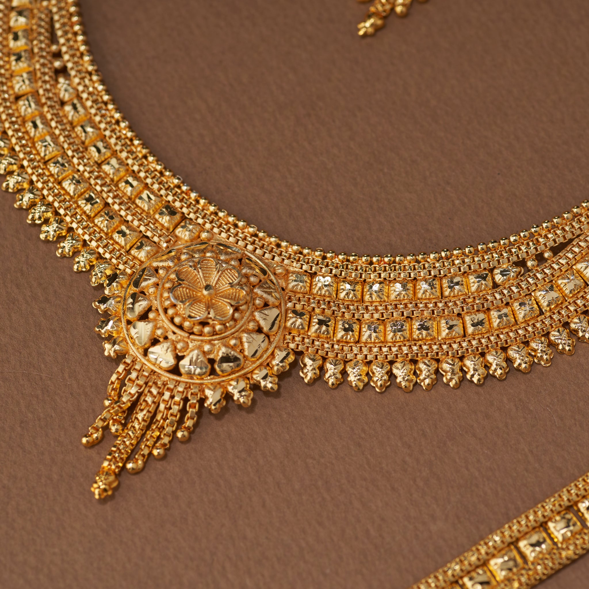 Traditional gold forming bridal jewellery set with short necklace, choker, long haaram, earrings, maang tikka and ring – perfect Indian bridal wedding jewellery with intricate temple-inspired design.