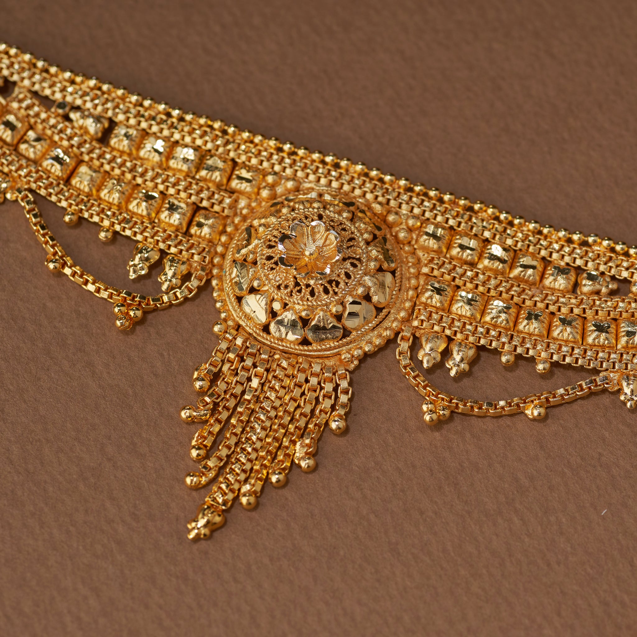 Traditional gold forming bridal jewellery set with short necklace, choker, long haaram, earrings, maang tikka and ring – perfect Indian bridal wedding jewellery with intricate temple-inspired design.