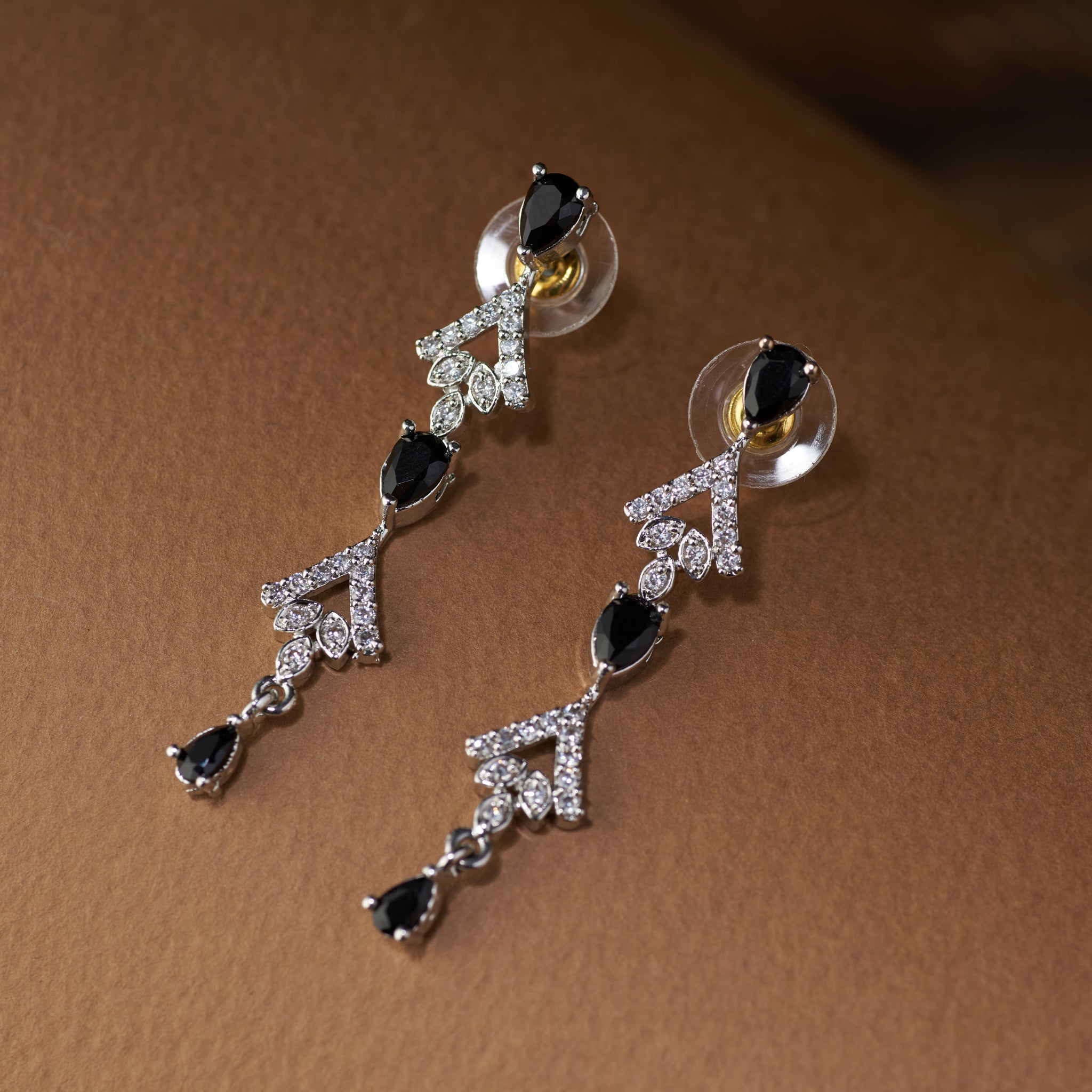 Teardrop Necklace and earrings with black cubic zircon stones and silver accents on a brown background