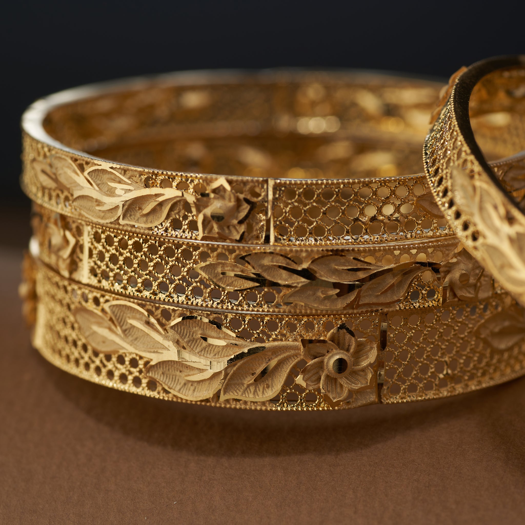 Discover the beauty of handcrafted gold forming replica bangles with detailed floral and leaf cutwork design. This versatile jewellery set is ideal for weddings, bridal looks, festive celebrations, and special occasions – bringing a touch of tradition and elegance to every outfit.