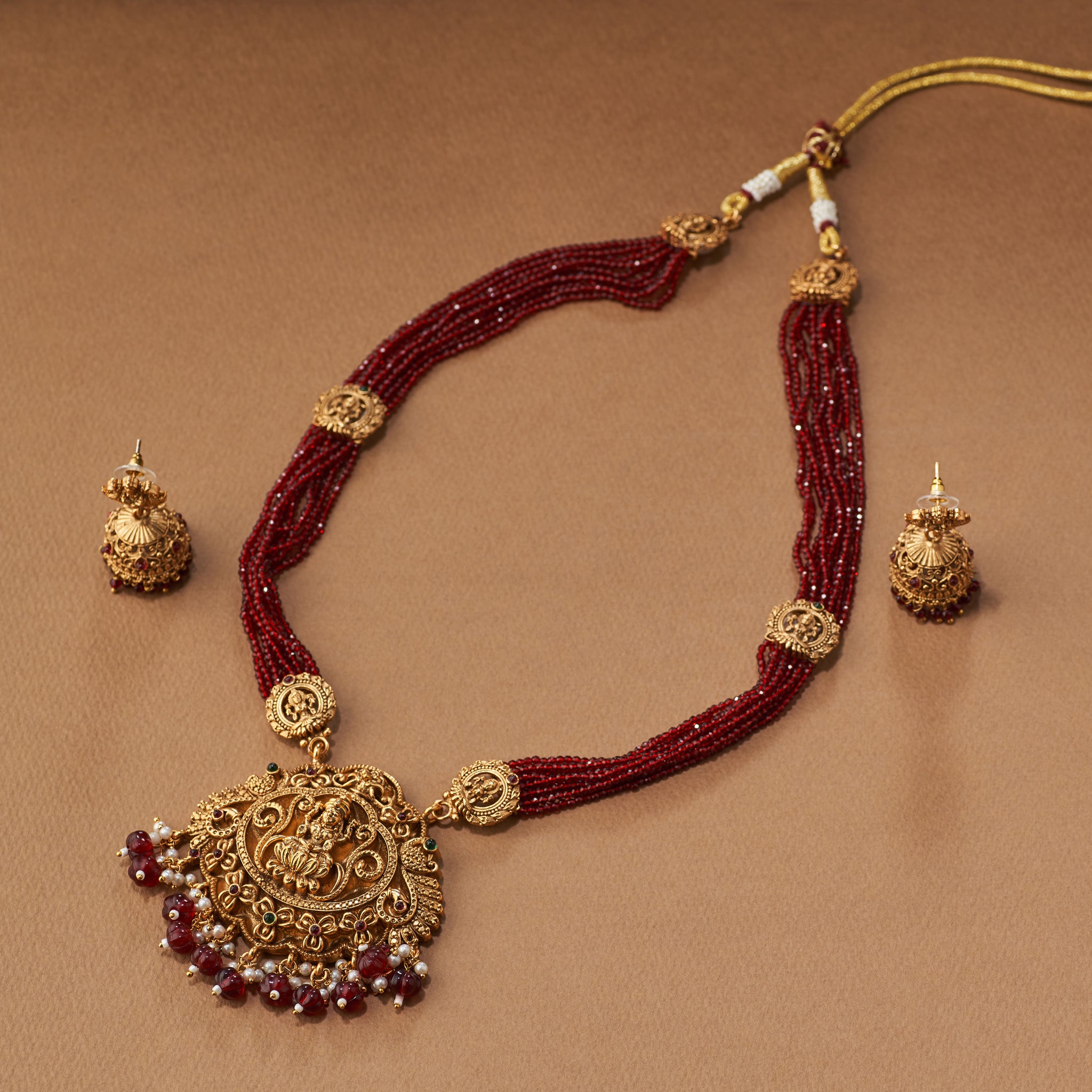 Maroon beaded gold Lakshmi pendant South Indian Temple jewellery necklace set with matching jumkhis or earrings. Matt gold plated.