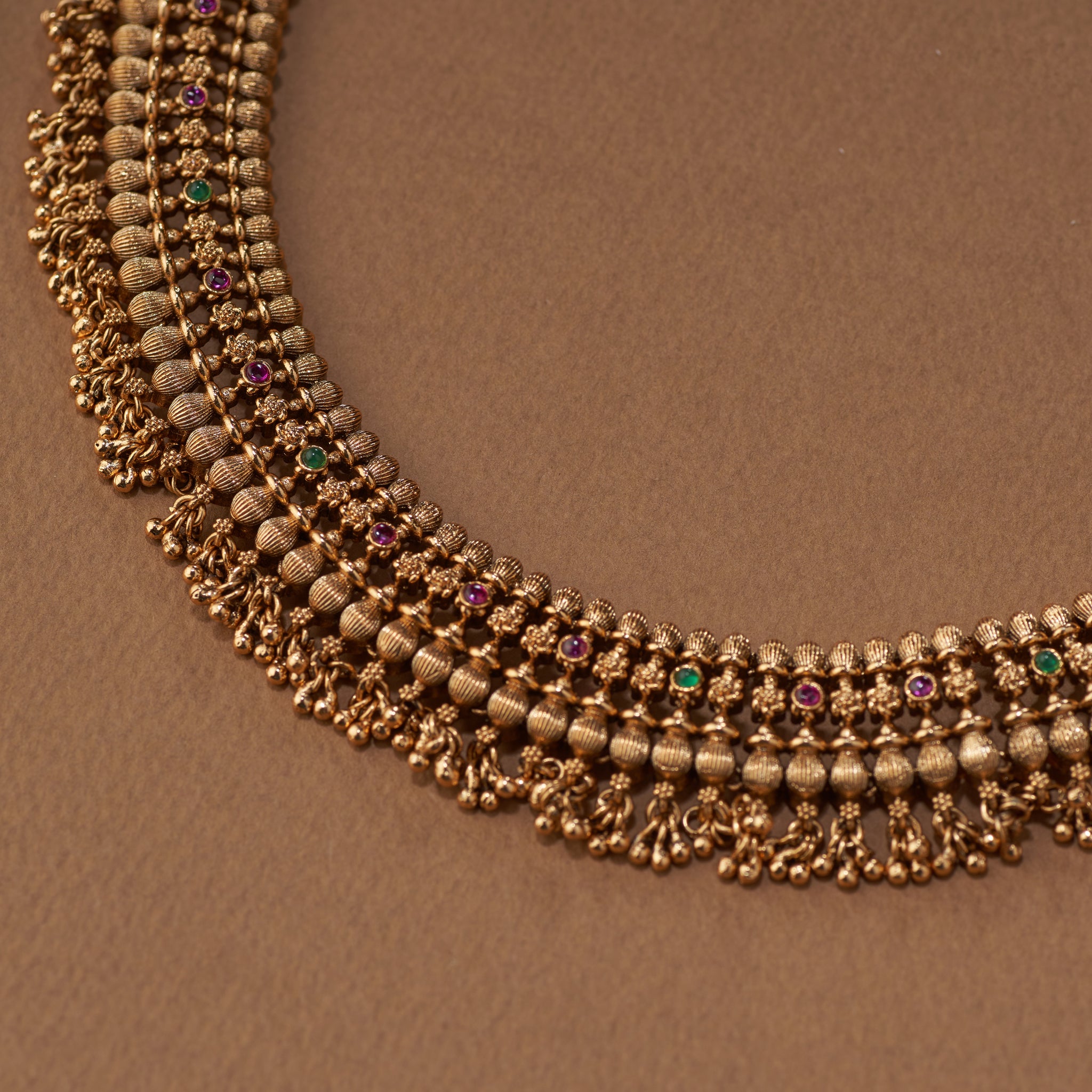 "Intricate heritage temple jewellery choker in antique gold with colourful stone detailing and matching earrings