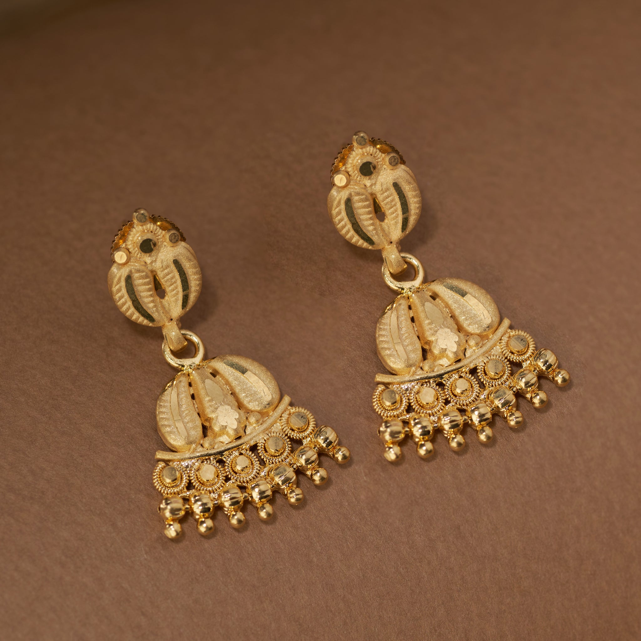 Pair of gold earrings. Gold necklace with matching earrings mango leaf pattern. Gold Forming Necklace Set | Kumarika by Tilloma.