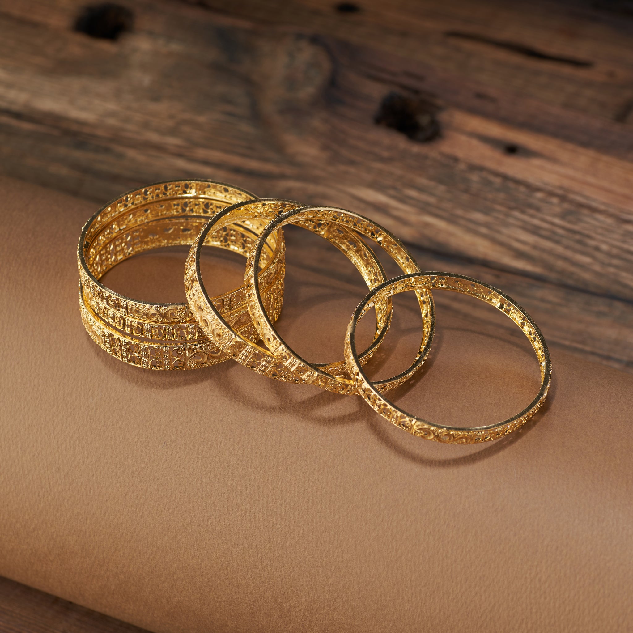 Add timeless elegance to your jewellery collection with this gold forming replica bangles set. Featuring detailed filigree and floral craftsmanship, these bangles are ideal for weddings, festive celebrations, and special occasions – the perfect blend of tradition and style.