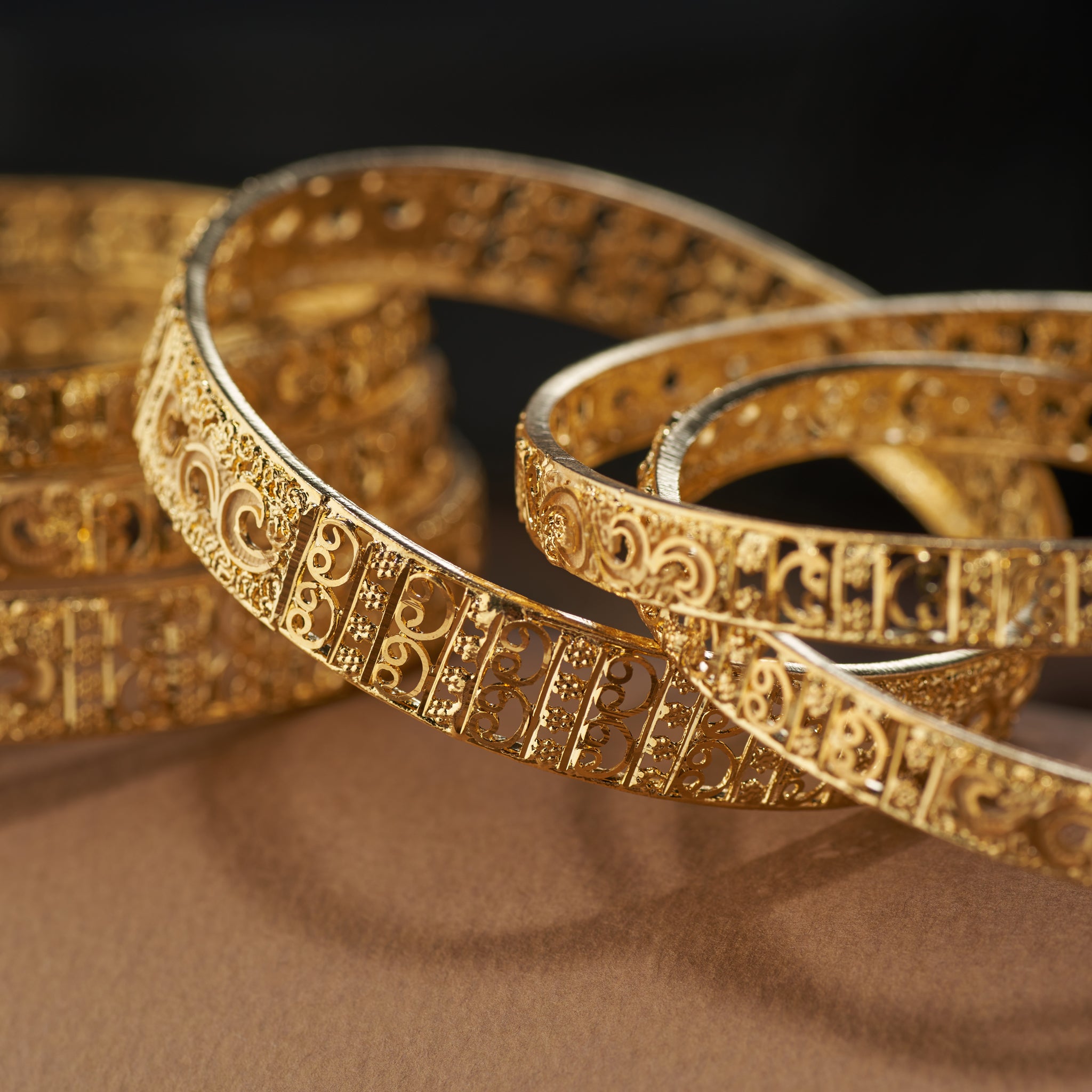 Add timeless elegance to your jewellery collection with this gold forming replica bangles set. Featuring detailed filigree and floral craftsmanship, these bangles are ideal for weddings, festive celebrations, and special occasions – the perfect blend of tradition and style.