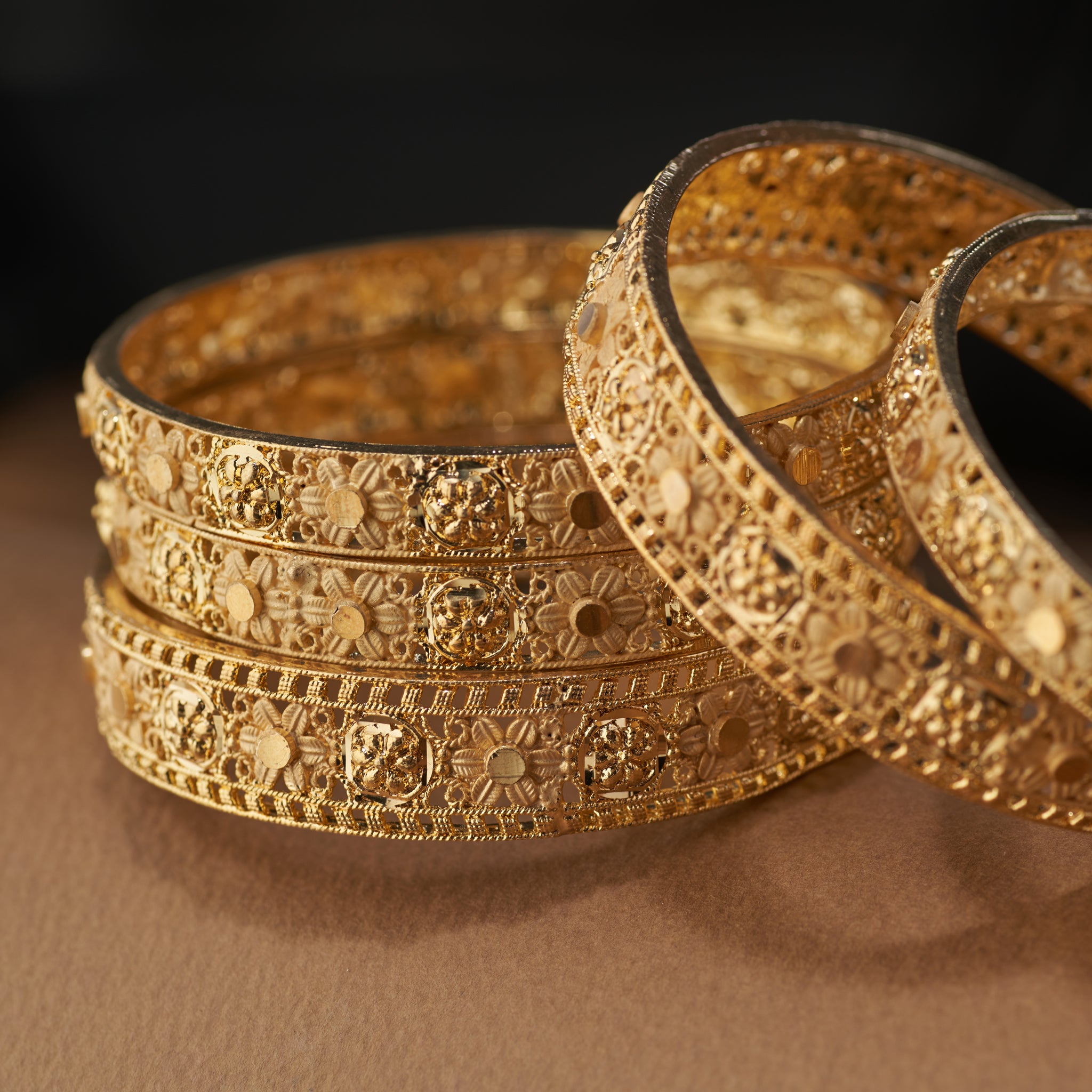 Complete your festive and bridal look with this stunning set of gold forming replica bangles. Designed with embossed floral motifs and intricate detailing, these bangles are the perfect accessory for weddings, cultural celebrations, and special occasions.