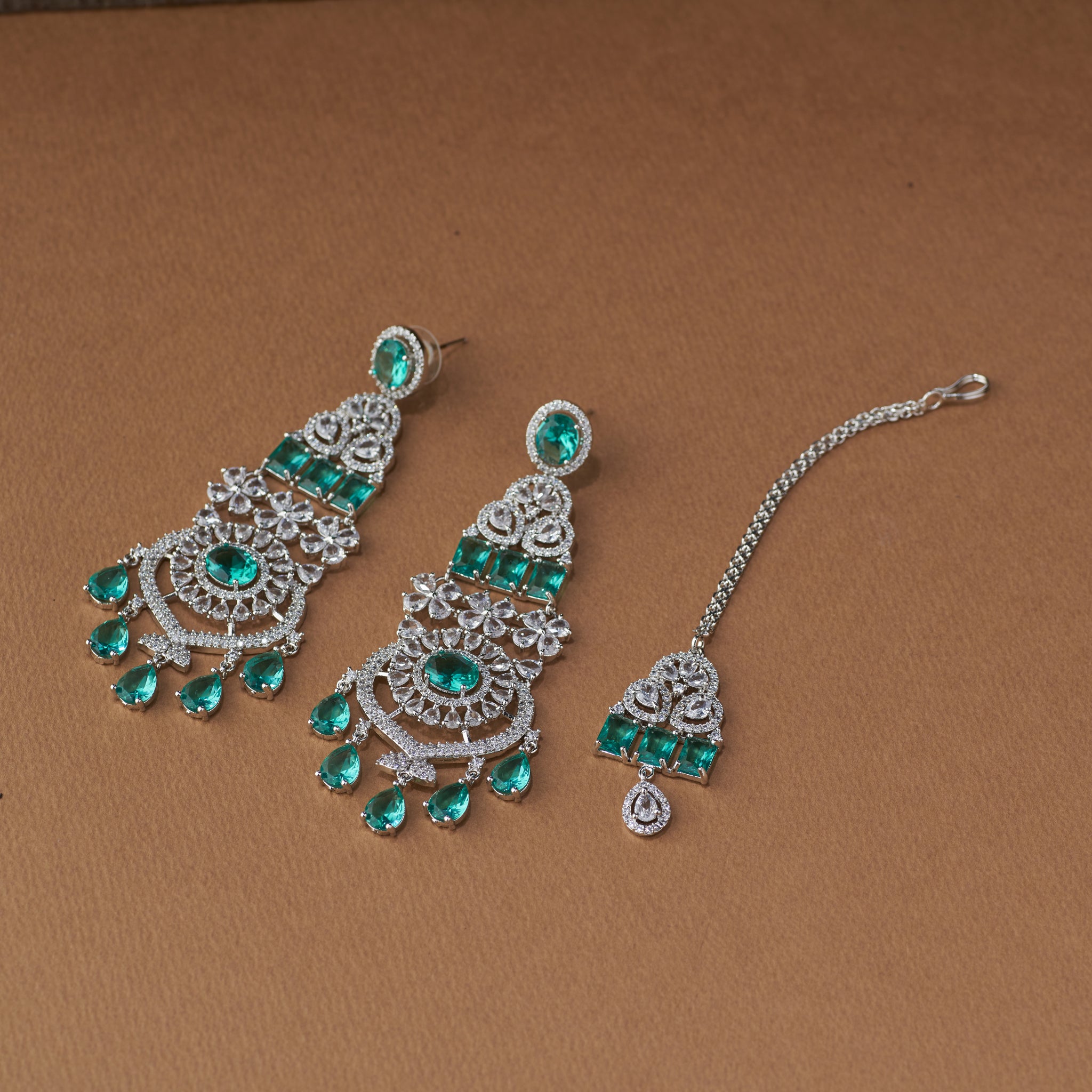 Elegant emerald and diamond bridal jewellery set with necklace, earrings, and maang tikka for weddings and special occasions.