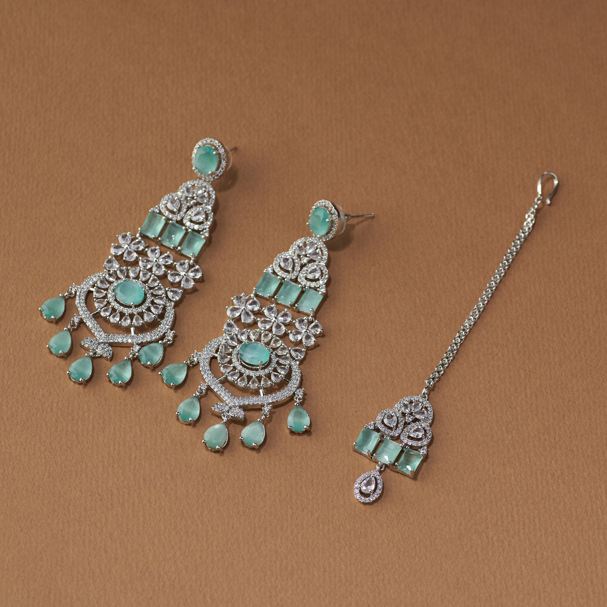Elegant emerald and diamond bridal jewellery set with necklace, earrings, and maang tikka for weddings and special occasions.
